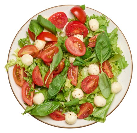 Foto de Ensalada con mozzarella, tomates cherry y lechuga verde en un plato redondo blanco, fondo aislado. Vista superior - Imagen libre de derechos