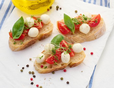 Foto de Mozzarella redonda, tomates cherry y microgreens en un pedazo de pan blanco, un sándwich saludable - Imagen libre de derechos