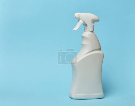 Foto de Botella de plástico blanco con spray sobre fondo azul, recipiente para productos químicos domésticos - Imagen libre de derechos