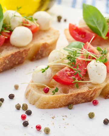 Foto de Mozzarella redonda, tomates cherry y microgreens en un pedazo de pan blanco, un sándwich saludable, de cerca - Imagen libre de derechos