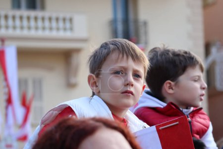 Foto de Mónaco, Mónaco - 11.19.2022: Los niños de Mónaco en el Día Nacional con las banderas del Principado - Imagen libre de derechos