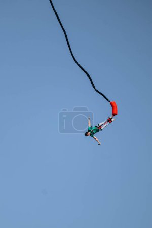 Bungee jumping from a great height while connected to a large elastic cord-stock-photo