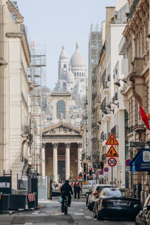 Foto de París, Francia - 16 de abril de 2023: calle Laffitte en el distrito 9 de París, iglesia de Notre Dame de Lorette y la Basílica del Sagrado Corazón al fondo - Imagen libre de derechos