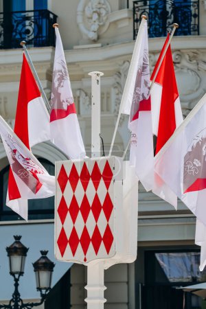 Foto de Mónaco, Mónaco - 25 de junio de 2023: Escudo de armas de Mónaco, así como banderas en honor del centenario del Príncipe Rainiero III - Imagen libre de derechos