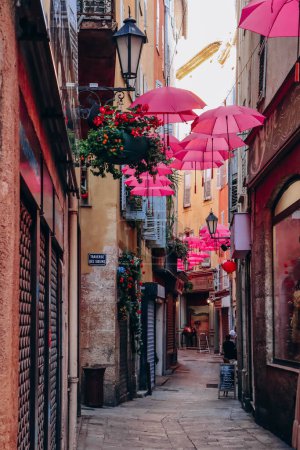 Foto de Grasse, Francia - 23 de julio de 2023: Famosos paraguas rosas decorando las calles centrales de Grasse - Imagen libre de derechos