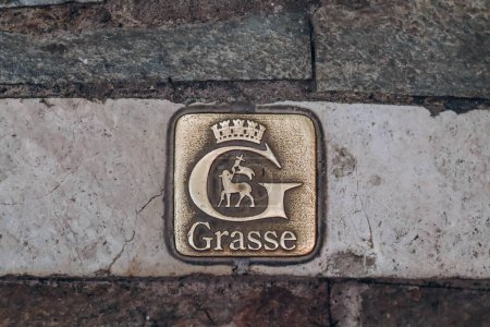 Téléchargez les photos : Grasse, France - 23 juillet 2023 : Emblème de Grasse sur le trottoir du centre-ville - en image libre de droit