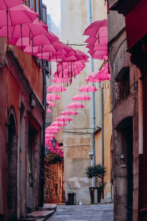 Foto de Grasse, Francia - 23 de julio de 2023: Famosos paraguas rosas decorando las calles centrales de Grasse - Imagen libre de derechos