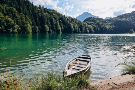 Téléchargez les photos : Bateau solitaire sur la rive de l'Alat Voir lac en Bavière, Allemagne - en image libre de droit