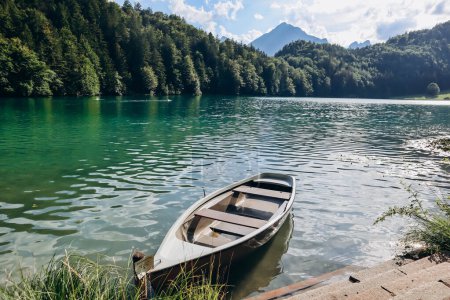 Téléchargez les photos : Bateau solitaire sur la rive de l'Alat Voir lac en Bavière, Allemagne - en image libre de droit