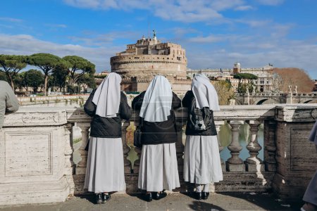 Téléchargez les photos : Nonnes sur le Ponte Vittorio Emanuele II regarder Rome et Castel Angelo - en image libre de droit