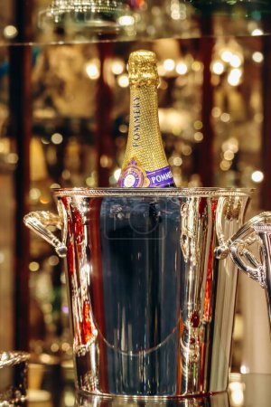 Foto de Florencia, Italia - 29 diciembre, 2023: Una botella de champán Pommery en un cubo de hielo y elegantes copas de cristal - Imagen libre de derechos