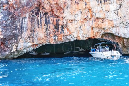 Téléchargez les photos : Bateau de plaisance avec des touristes près d'une grotte dans la mer Adriatique au Monténégro - en image libre de droit