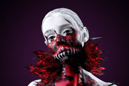 Frau mit Fleischfresserblume, die sich auf dunklem Hintergrund ins Gesicht gemalt hat. Halloween-Konzept