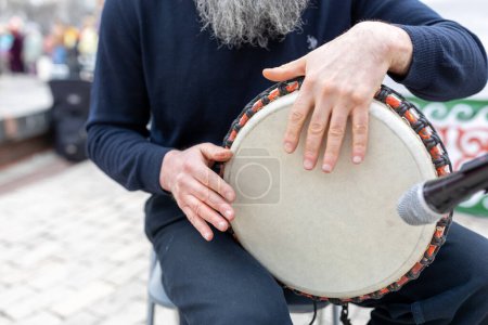 Téléchargez les photos : Dabyl. Instrument de musique folk kazakh. mans mains jouant le double extérieur - en image libre de droit