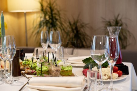 Téléchargez les photos : Table servie avec verres à vin vides dans un restaurant français. atmosphère chaleureuse - en image libre de droit