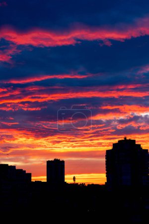 Ciel nuageux de couleur rouge orangé après le coucher du soleil, formation de nuages, ciel nocturne, coucher du soleil. Kiev, Ukraine. Maisons de ville contre le ciel du soir