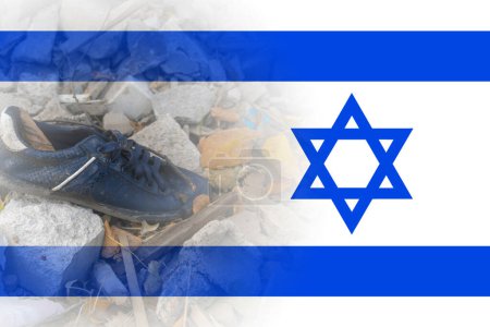 A sneaker lies on the ruins of a house against the backdrop of the Israeli flag. Israeli-Palestinian conflict. Terror of civilians