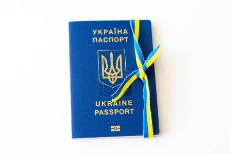 Reisepass eines Ukrainers, gebunden mit einem Band in der Farbe dieser Landesflagge.