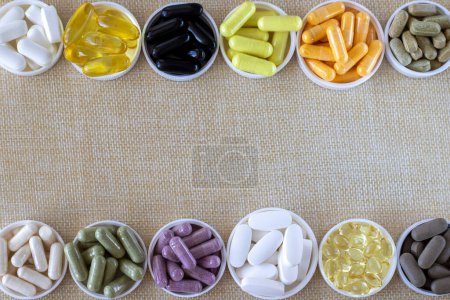 Gemischte Pille Hintergrund, Draufsicht. Nahrungsergänzungsmittel, Vitamine und organische Mineralien. auf beigem Hintergrund. Kopierraum. Rahmen aus Tabletten