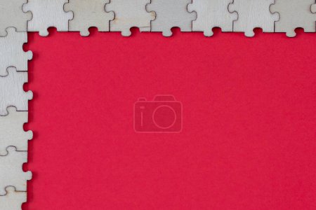 Téléchargez les photos : Pièces de puzzle sur fond rouge. Cadre d'angle de puzzles en bois vierges - en image libre de droit