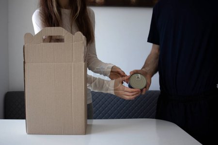 Téléchargez les photos : Unpacking a weeks worth of food. A woman and a man are unpacking boxes of groceries - en image libre de droit