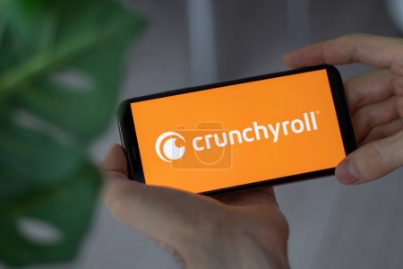 Photo for IRPEN, UKRAINE - JANUARY 20 20223, Closeup of smartphone screen Crunchyroll logo lettering with in mans hands, Illustrative Editorial - Royalty Free Image