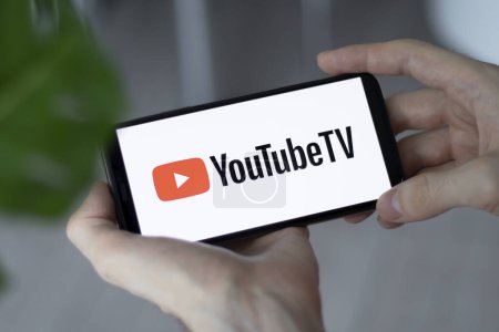 Photo for IRPEN, UKRAINE - JANUARY 20 20223, Closeup of smartphone screen YouTube TV logo lettering with in mans hands, Illustrative Editorial - Royalty Free Image