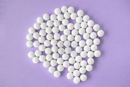 Photo for White round tablets, magnesium supplements on a light purple background - Royalty Free Image