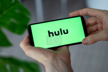 Photo for IRPEN, UKRAINE - JANUARY 20 20223, Closeup of smartphone screen Hulu logo lettering with in mans hands, Illustrative Editorial - Royalty Free Image