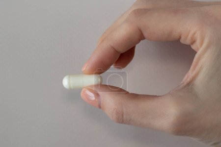 Vitamin D3 plus K2 in a woman's hand one capsule.