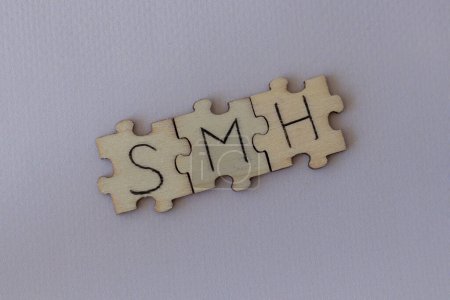 Foto de El acrónimo SMH, que significa Sacudir mi cabeza. Las cartas escritas en los puzzles - Imagen libre de derechos