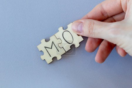 Téléchargez les photos : L'acronyme MO, qui signifie Modus Operandi. Les lettres écrites sur les puzzles - en image libre de droit
