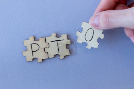 The acronym PTO, which stands for Paid Time Off. The letters written on the puzzles