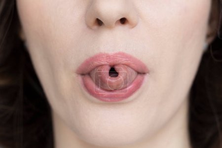 Photo for A woman shows her tongue folded into a tube, close-up - Royalty Free Image