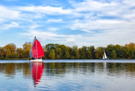 Photo for Two yachts on the Dnieper River against the backdrop of an autumn landscape. Ukraine, Kyiv, Obolonsky district near a residential area, wild nature. - Royalty Free Image