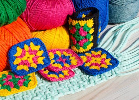 Ganchillo, patrones hechos a mano e hilos de colores. Colorido cuadrado de algodón abuela. Textura de ganchillo de cerca.