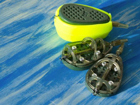 Photo for Flat feeders for fishing, accessories for fishing, top view on a turquoise background. - Royalty Free Image