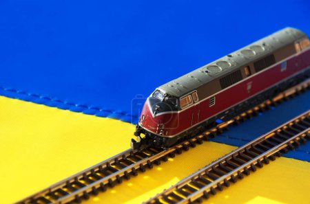 Téléchargez les photos : Modèle d'une locomotive sur le drapeau ukrainien. Chemin de fer ukrainien. - en image libre de droit