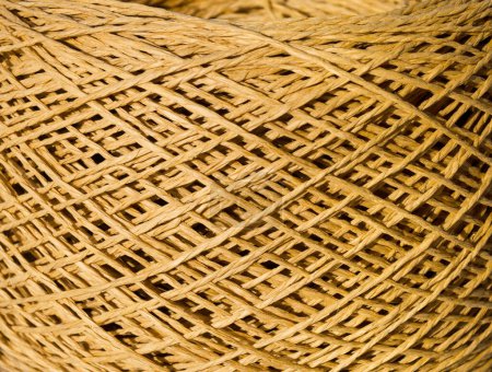 Raffia close-up. A skein of mustard colored raffia is ready for knitting. Eco material for handmade work.