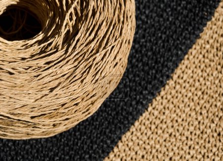 Close-up of a skein of ECO raffia against a background of black and beige napkins. Crochet. Eco material for handmade work.