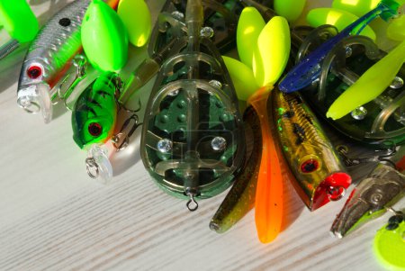 Fishing tackle on a wooden background. Float, flatt, silicone bait, spinner. Background for a fishing theme.