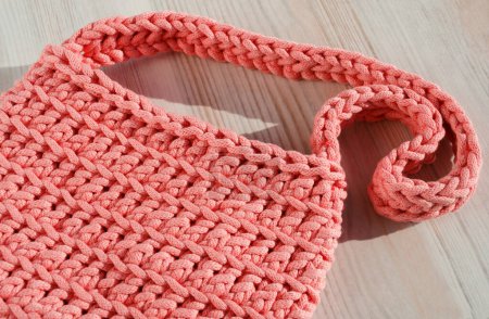 Foto de Bolso de mujer pequeño hecho de cordón de algodón. Bolso de mano rosa sobre fondo claro. - Imagen libre de derechos