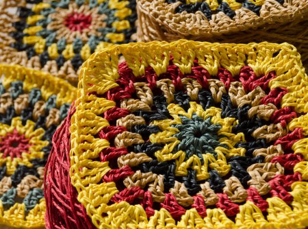 Crocheted raffia patterns. Granny square made of multi-colored raffia. Eco-friendly handmade material.