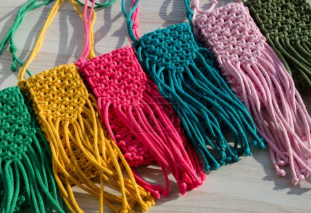 A little bag. Knitting macrame, pattern of multi-colored cotton cords. Handmade concept, hobby, background, fashionable online knitting course.