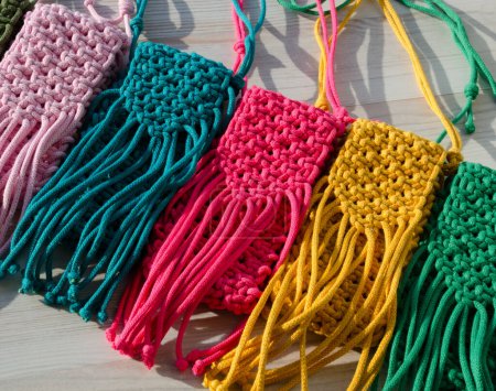 Un petit sac. Macramé à tricoter, motif de cordons de coton multicolores. Concept fait main, passe-temps, arrière-plan, cours de tricot en ligne à la mode.