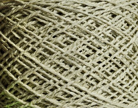 An olive skein of raffia is ready for knitting. Eco-friendly handmade material. Raffia close-up.