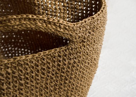 Women's raffia bag close-up. Raffia knitting texture, kraft colors. Crocheted bags, clutches. Eco material for handmade work.