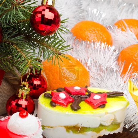 Gâteaux du Nouvel An, branches d'arbre de Noël, boules, mandarines, tinsel et arc. Endroit pour le texte. Humeur festive de Noël et du Nouvel An.