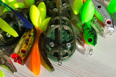 Fishing tackle on a wooden background. Float, flatt, silicone bait, spinner. Background for a fishing theme.