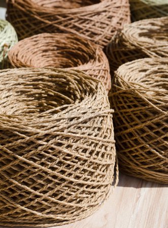 Foto de Bolas de rafia de cerca sobre un fondo de arpillera. Las madejas de rafia están listas para tejer - Imagen libre de derechos